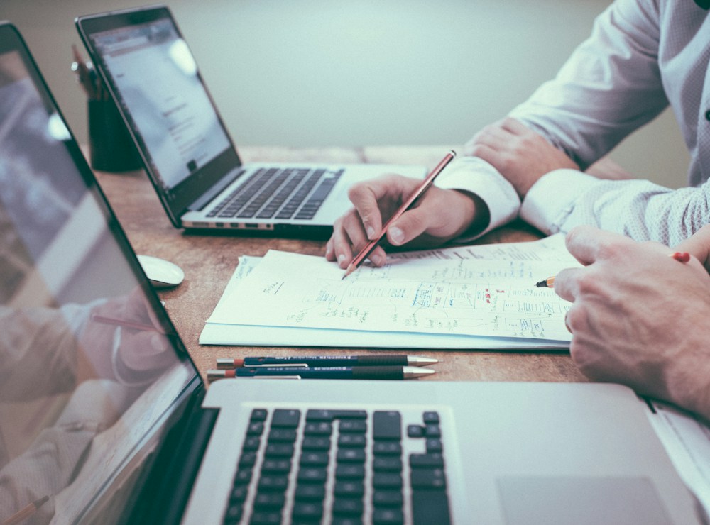 Profissionais analisando relatórios e gráficos em uma mesa de trabalho