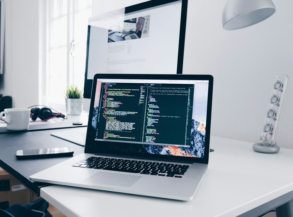 Notebook com editor de código em uma mesa de desenvolvimento
